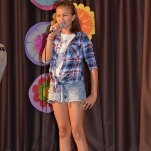 Zdjęcie przedstawia uczestniczkę półkolonii podczas występu w Talent Show w GOKu