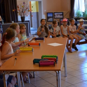 Zdjęcie przedstawia uczestników półkolonii podczas warsztatów muzycznych