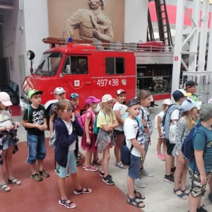 Zdjęcie przedstawia uczestników półkolonii podczas wizyty w Muzeum Straży Pożarnej