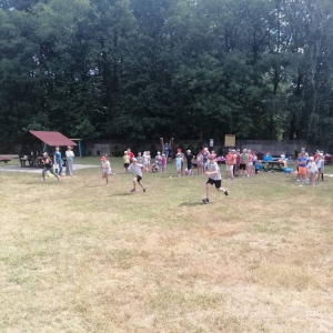 Zdjęcie przedstawia uczestników półkolonii podczas wspólnej zabawy na boisku sportowym w Nakle Śl.