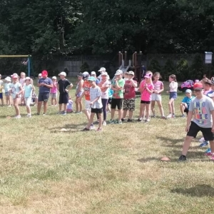 Zdjęcie przedstawia uczestników półkolonii podczas wspólnej zabawy na boisku sportowym w Nakle Śl.