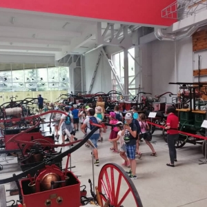 Zdjęcie przedstawia uczestników półkolonii podczas wizyty w Muzeum Straży Pożarnej