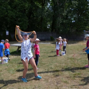 Zdjęcie przedstawia uczestników półkolonii podczas wspólnej zabawy na boisku sportowym w Nakle Śl.