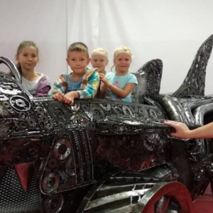 Zdjęcie przedstawia uczestników półkolonii podczas wizyty w Galerii Figur Stalowych