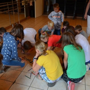 Zdjęcie przedstawia wspólną pracę plastyczną tworzenia znaku grupy