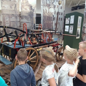 Zdjęcie przedstawia uczestników półkolonii podczas wizyty w Muzeum Straży Pożarnej