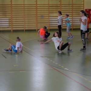Zdjęcie przedstawia uczestników półkolonii podczas zajęć sportowych na Hali Sportowej w Nakle Śl.