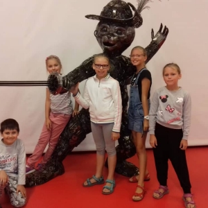 Zdjęcie przedstawia uczestników półkolonii podczas wizyty w Galerii Figur Stalowych