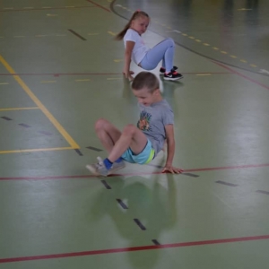 Zdjęcie przedstawia uczestników półkolonii podczas zajęć sportowych na Hali Sportowej w Nakle Śl.