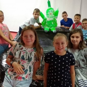 Zdjęcie przedstawia uczestników półkolonii podczas wizyty w Galerii Figur Stalowych