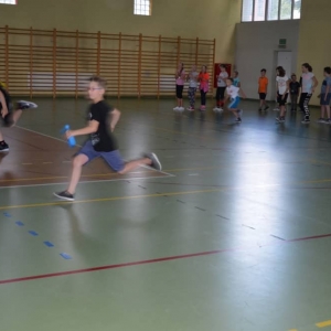 Zdjęcie przedstawia uczestników półkolonii podczas zajęć sportowych na Hali Sportowej w Nakle Śl.