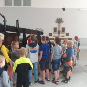 Zdjęcie przedstawia uczestników półkolonii podczas wizyty w Muzeum Straży Pożarnej