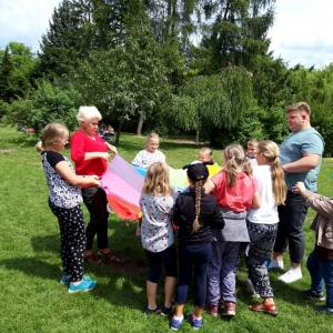 Zdjęcie przedstawia uczestników półkolonii podczas wspólnej zabawy na świeżym powietrzu przy Osikowej Dolinie