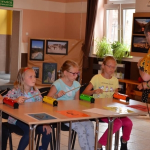 Zdjęcie przedstawia uczestników półkolonii podczas warsztatów muzycznych