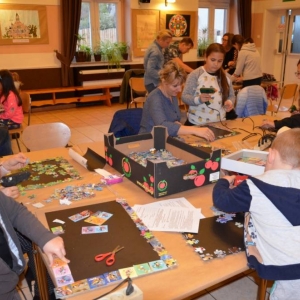 Zdjęcie przedstawia uczestników warsztatów rodzinnych podczas wykonywania swoich prac - tablic magnetycznych