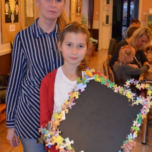 Zdjęcie przedstawia uczestniczki warsztatów rodzinnych z wykonaną tablicą magnetyczną