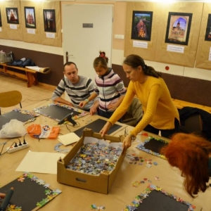 Zdjęcie przedstawia uczestników warsztatów rodzinnych podczas wykonywania swoich prac - tablic magnetycznych