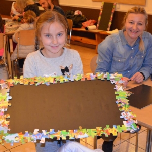 Zdjęcie przedstawia uczestniczki warsztatów rodzinnych z wykonaną tablicą magnetyczną