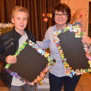 Zdjęcie przedstawia uczestników warsztatów rodzinnych z wykonanymi tablicami magnetycznymi