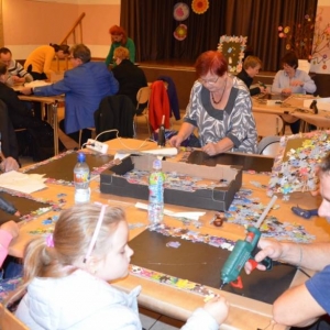 Zdjęcie przedstawia uczestników warsztatów rodzinnych podczas wykonywania swoich prac - tablic magnetycznych