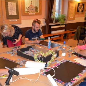 Zdjęcie przedstawia uczestników warsztatów rodzinnych podczas wykonywania swoich prac - tablic magnetycznych