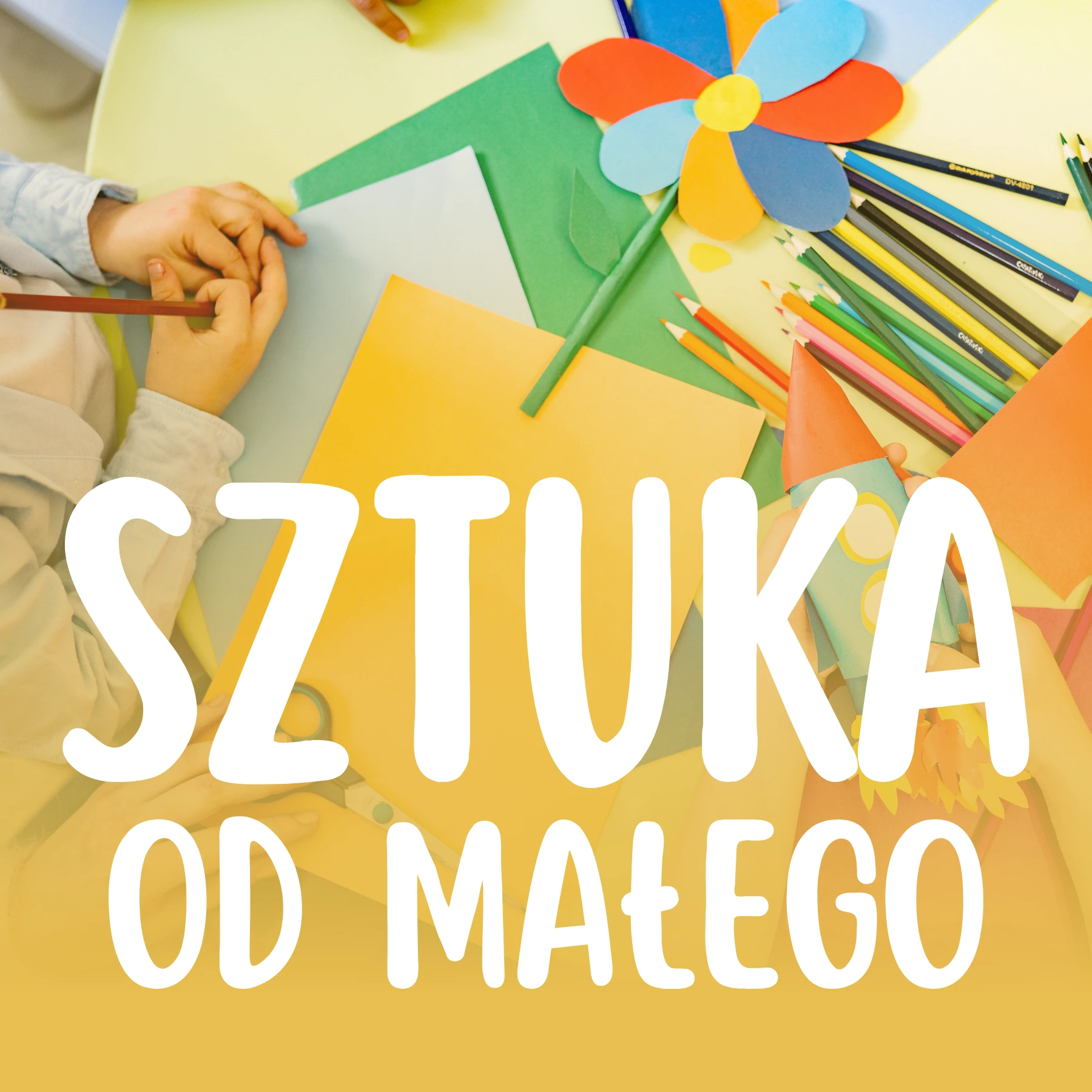 Widok z góry na dłonie dziecka tworzącego pracę plastyczną z kolorowego papieru i kredek, przesłonięty dużym białym napisem „SZTUKA OD MAŁEGO”.